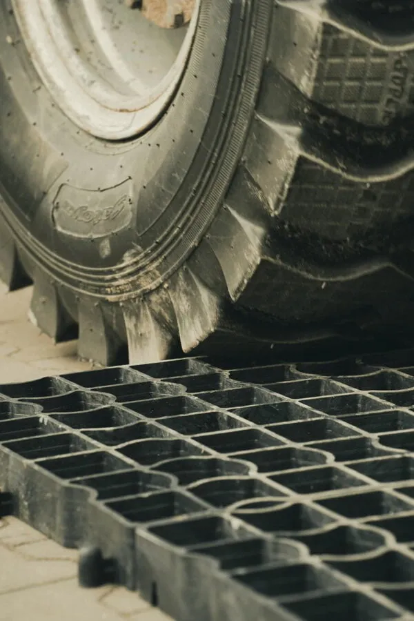 Duże koło najeżdżające na kratkę parkingową