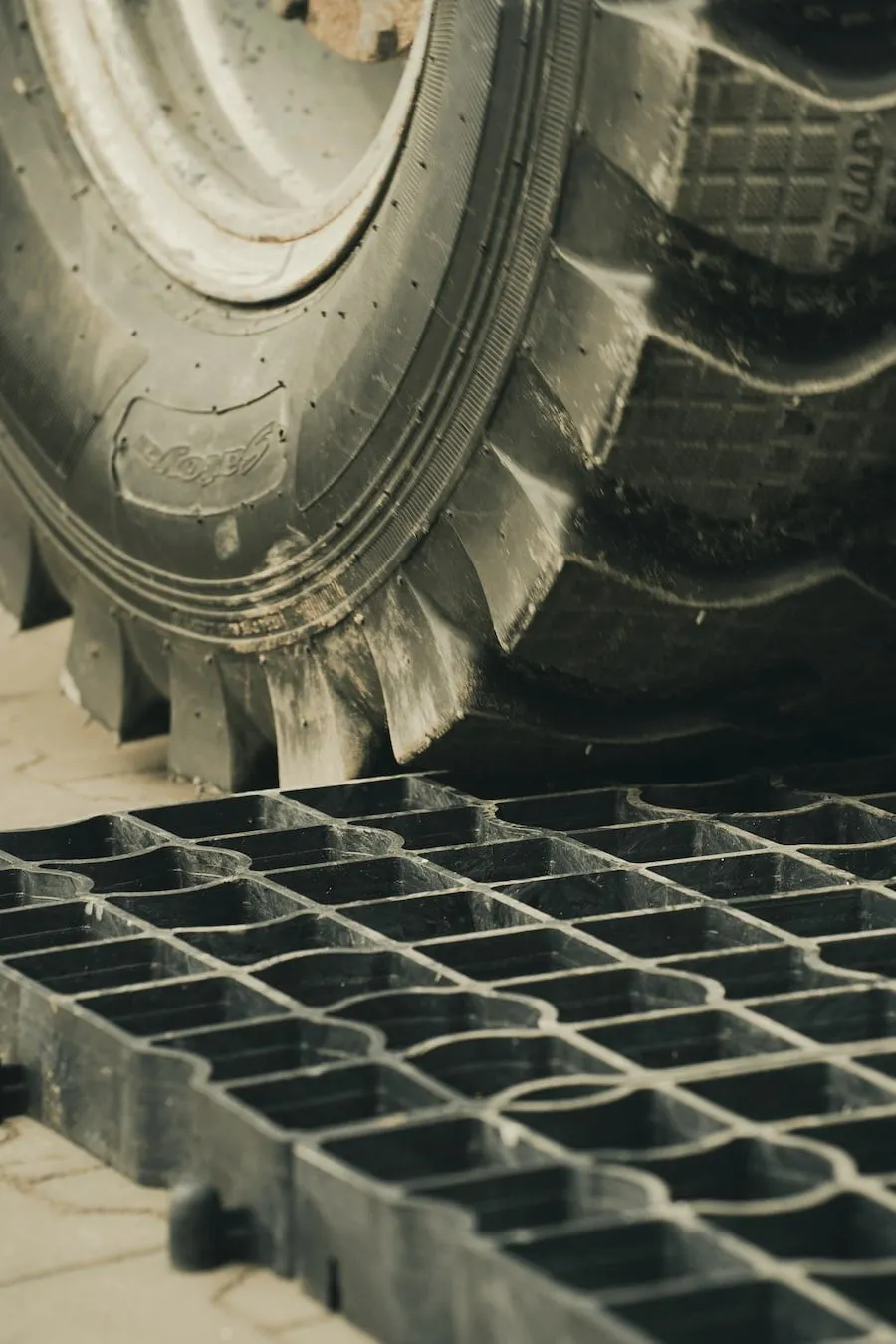 Duże koło najeżdżające na kratkę parkingową